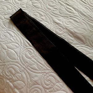 Black leather belt, tapered, meant to be double strapped and tied.